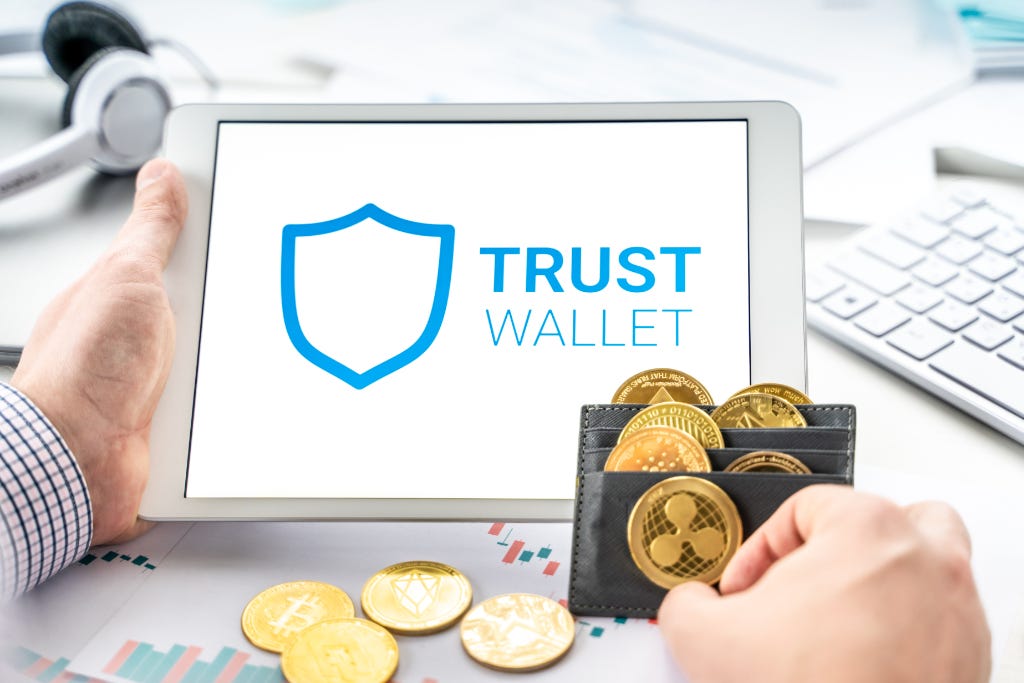 Trust Wallet on mobile device and leather wallet with crypto coins