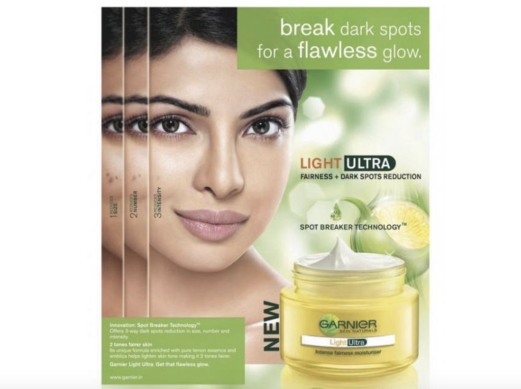 An ad featuring a close-up on Priyanka Chopra’s face on the left and a jar of skin lightening cream in the right foreground.