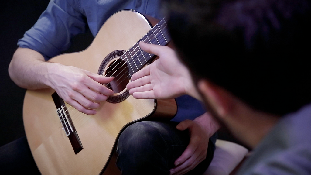 good classical guitar teacher demonstrates technique