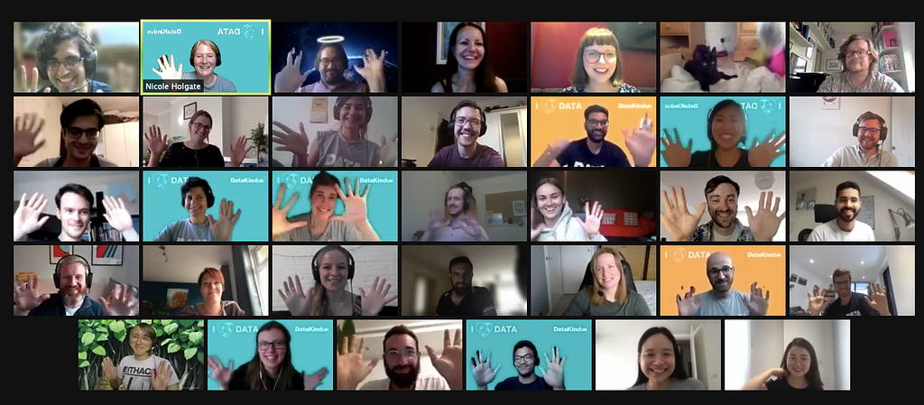 A screenshot of a Zoom call with roughly 30 young adults (DataDive weekend volunteers) smiling and waving, with colourful backgrounds