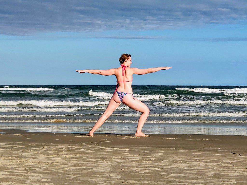 Foto da Ana praticando yoga à beira mar