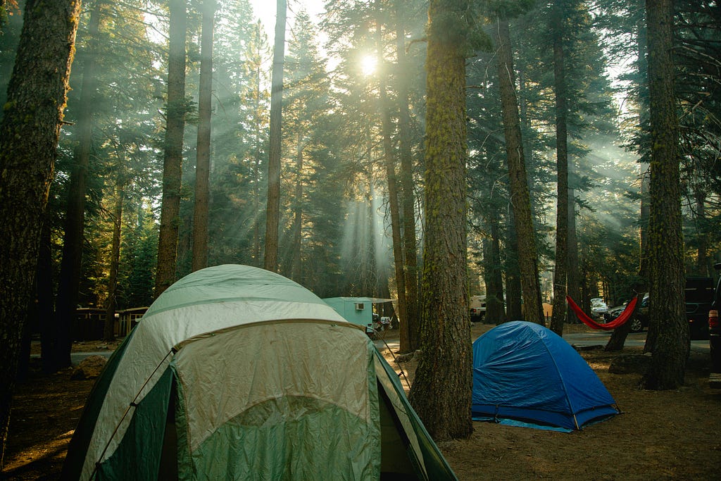 A campsite in the woods — photo courtesy of Awar Memen and Unsplash.