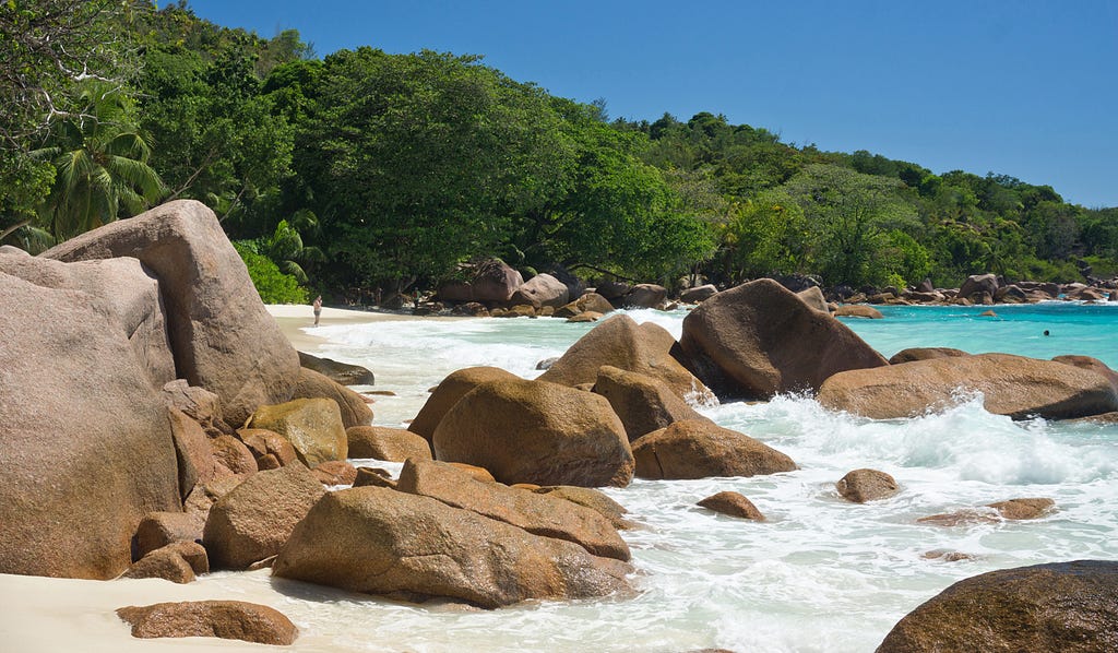 Reddish granite rocks line the shore of idyllic Anse Lazio on the Seychelles’ Praslin Island. © April Orcutt