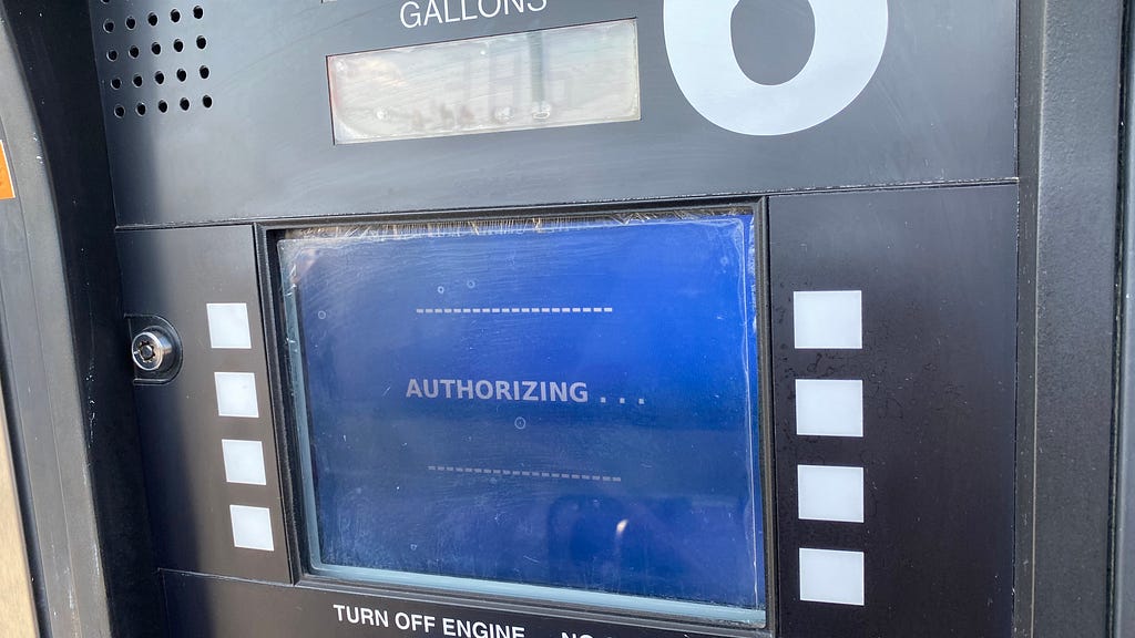 The blue payment screen at a gas pump that says authorizing.