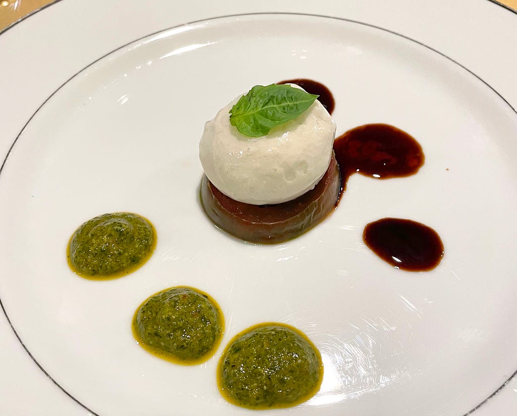 Burrata, similar to Caprese salad, only with Hemp-based mozzarella and pesto, matched with a black truffle balsamic reduction