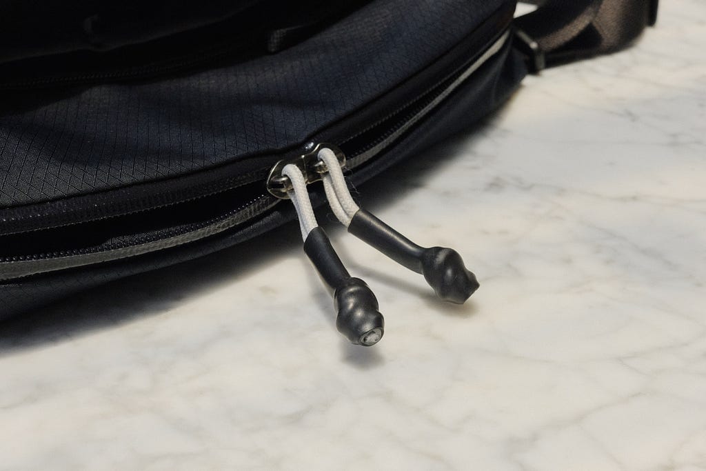 Heat-shrank zipper pulls on slate Bellroy Lite Sling