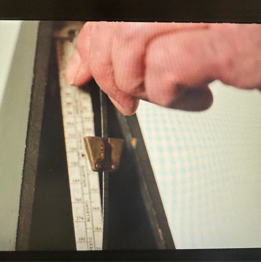 A hand adjusting an old metronome.