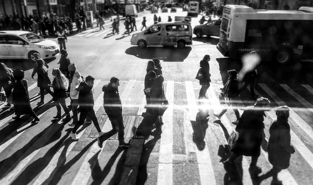 A crowd of people in a crosswalk.
