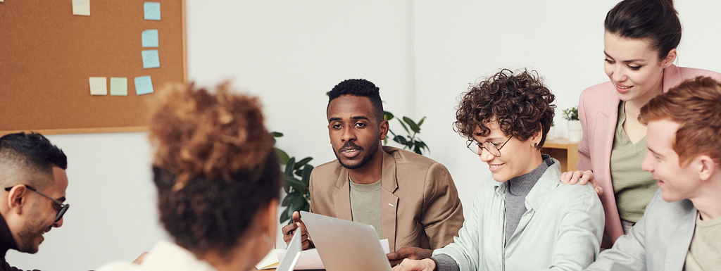 A group of happy employees doing their jobs while discussing with each other.