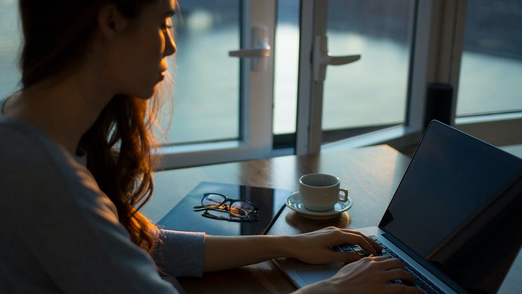 Woman in shadow in front of laptop