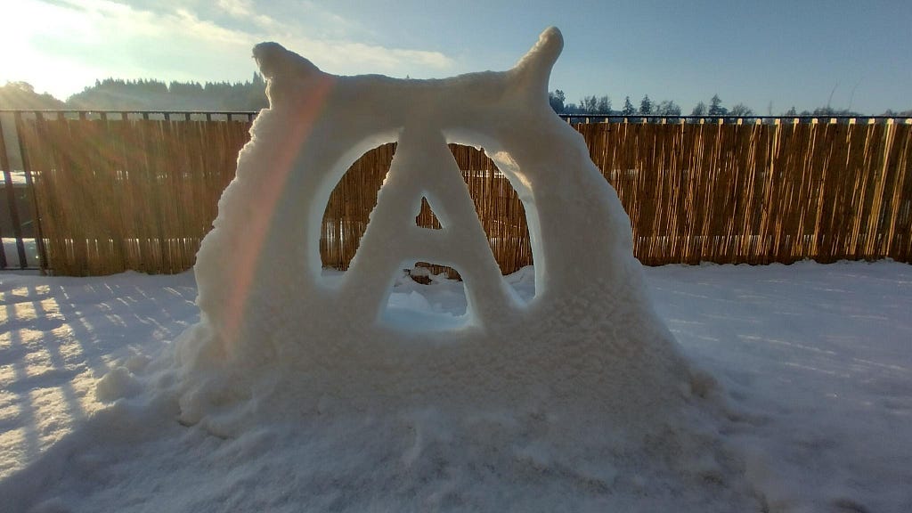 Snow sculpture of a circle A, the anarchist symbol
