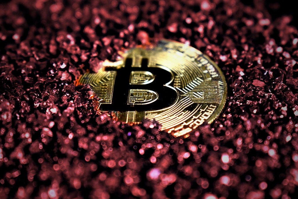 A gold ‘bitcoin’ in red glitter.