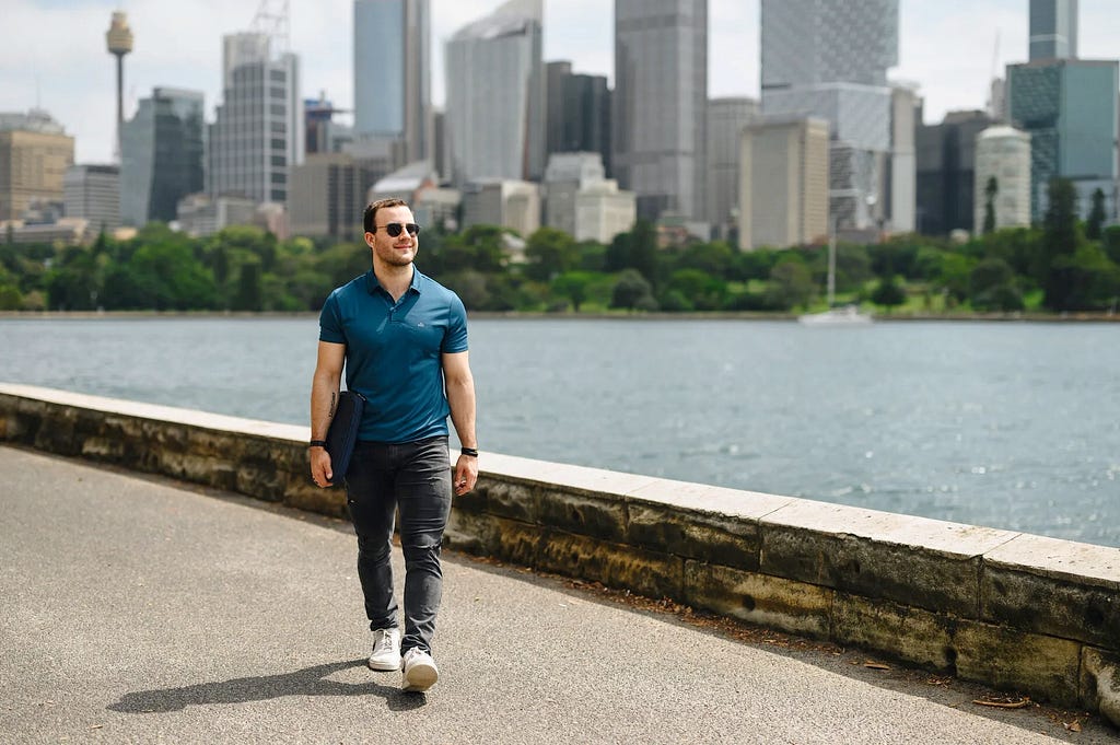 Me, walking with my laptop bag in front of Sydney Skyline