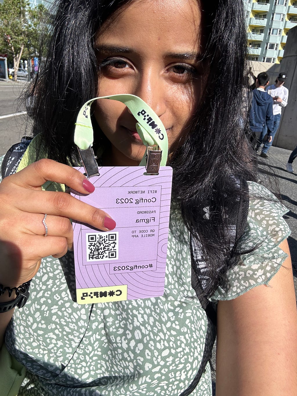 A selfie photo of a woman showing an entry card to config event.