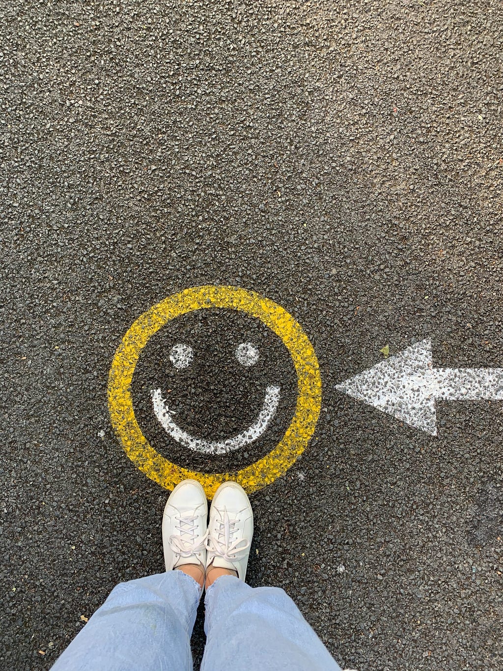 A person’s feet in front of a smiling emoji