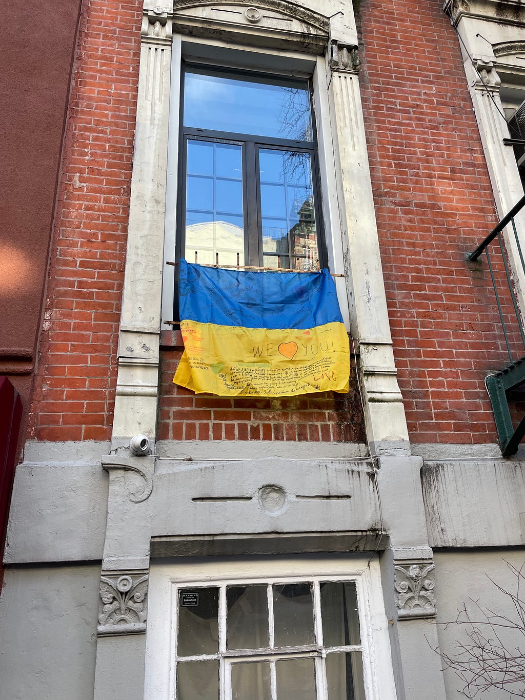 Photo of the Ukrainian Flag in a window in the Little Ukraine neighborhood of the East Village of New York.