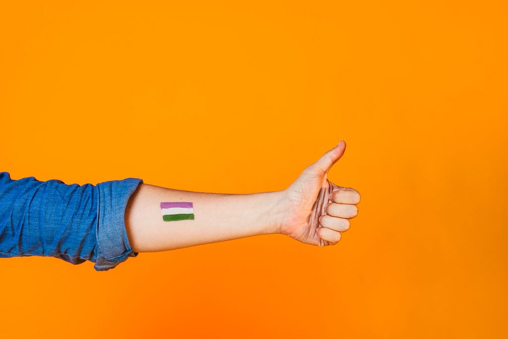 Genderqueer pride flag painted on the arm of someone celebrating pride