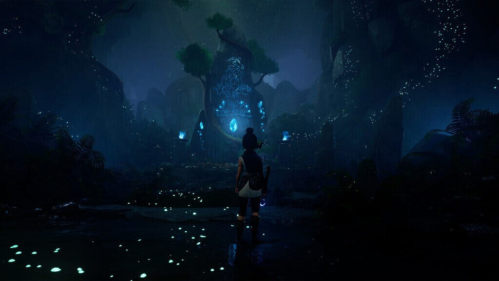 kena in front of a spirit stone with glowing blue light around