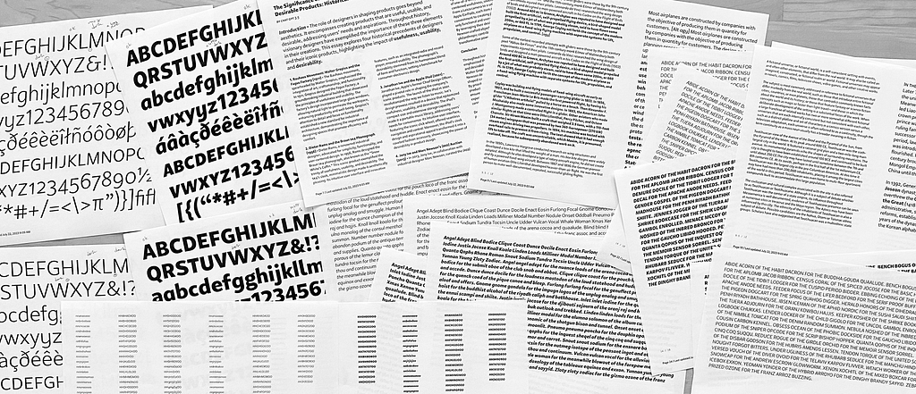 Overhead photo of many pages, printed with text in Peasy at different sizes
