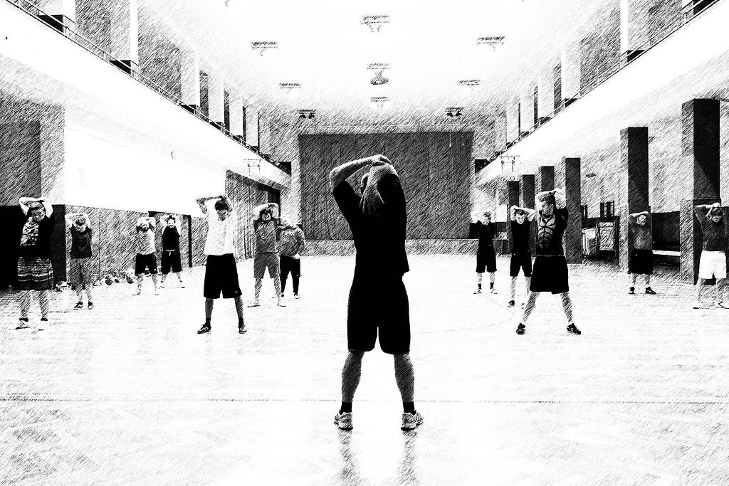 Black and white image of a large hall filled with people stretching their arm over their head. They’re all in sports clothes, suggesting they’re there for an exercise class. Warm-ups before meetings are just as important as warm-ups before exercising!
