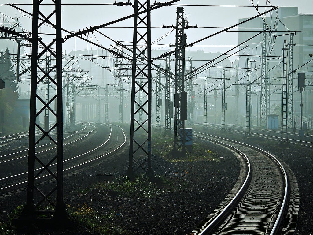 Railway lines stretching into a foggy urban landscape.