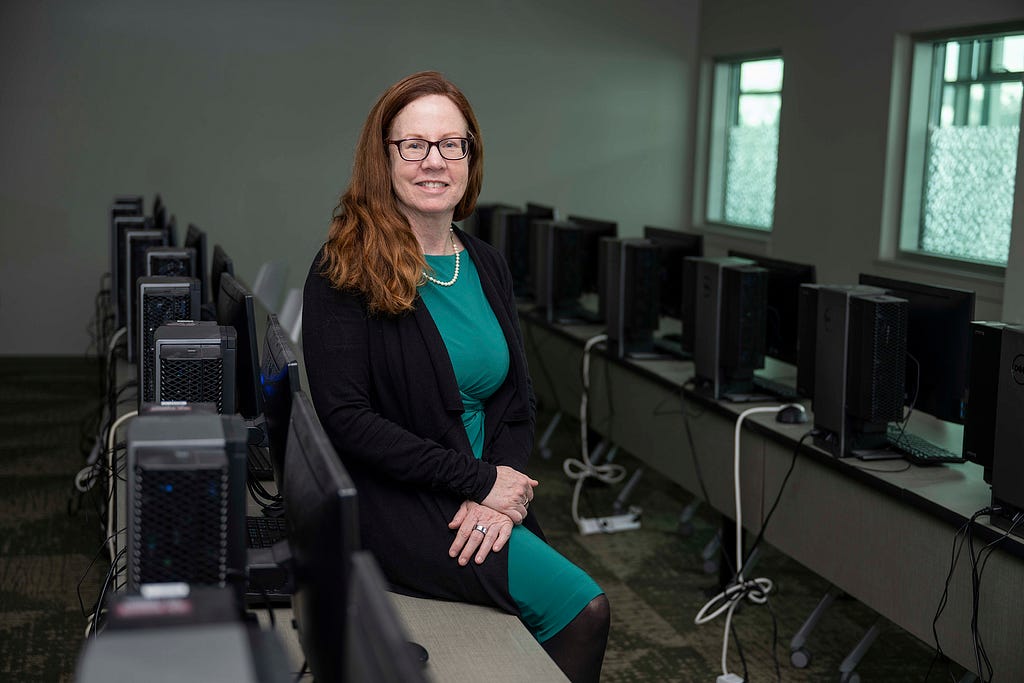 A picture of Dianne Burke in a computer classroom.