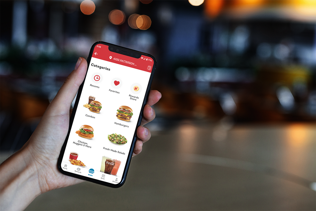 An image of someone using the Wendy’s app on a phone while on the go.