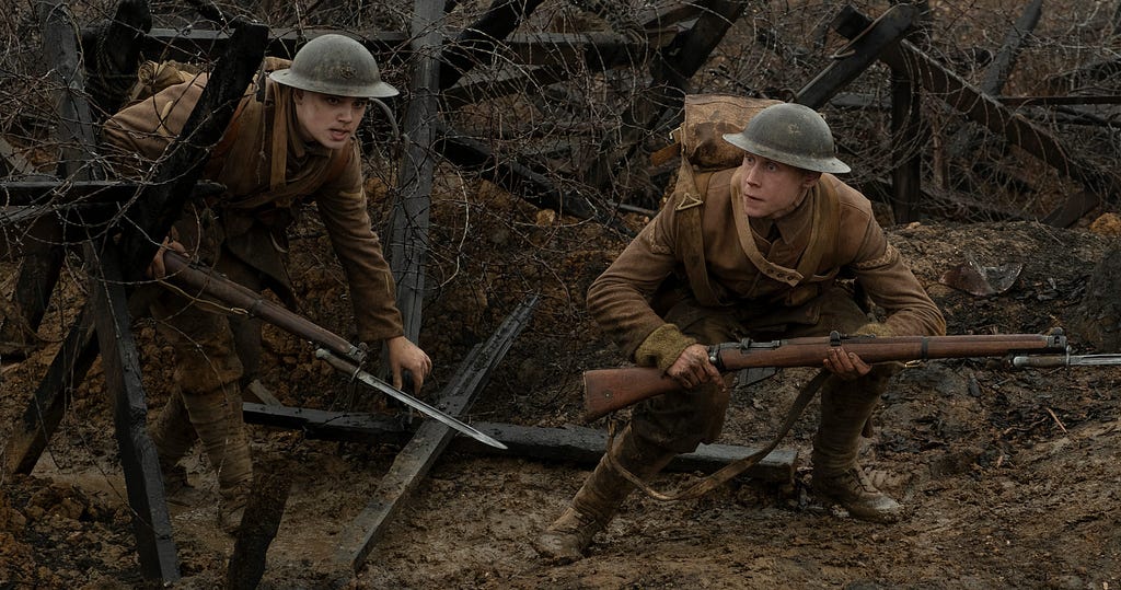 Scene from the movie 1917, the two leads duck beneath barbed wire into enemy territory.