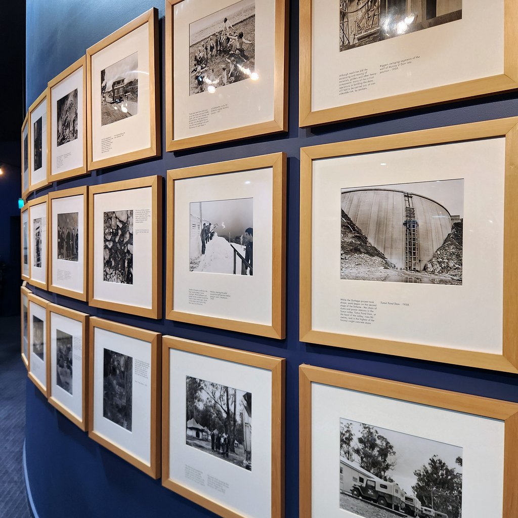 A wall of framed black and white photos showing the construction of the hydro-electric scheme