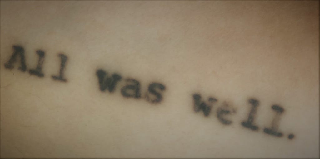 Fading tattoo that reads “All was well.” in a typewriter font