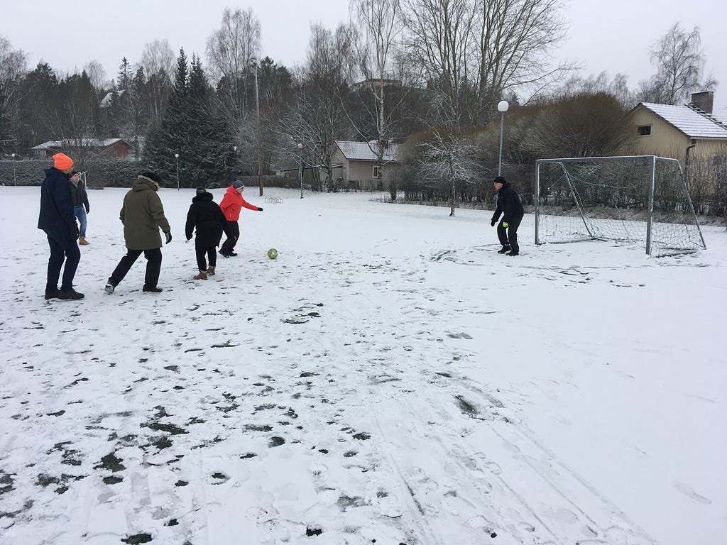 A group of people playing “walking football” in the snow
