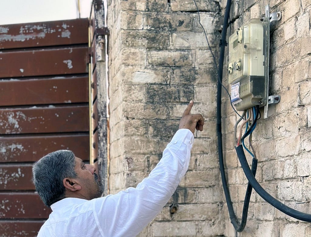 A man points to a smart meter.