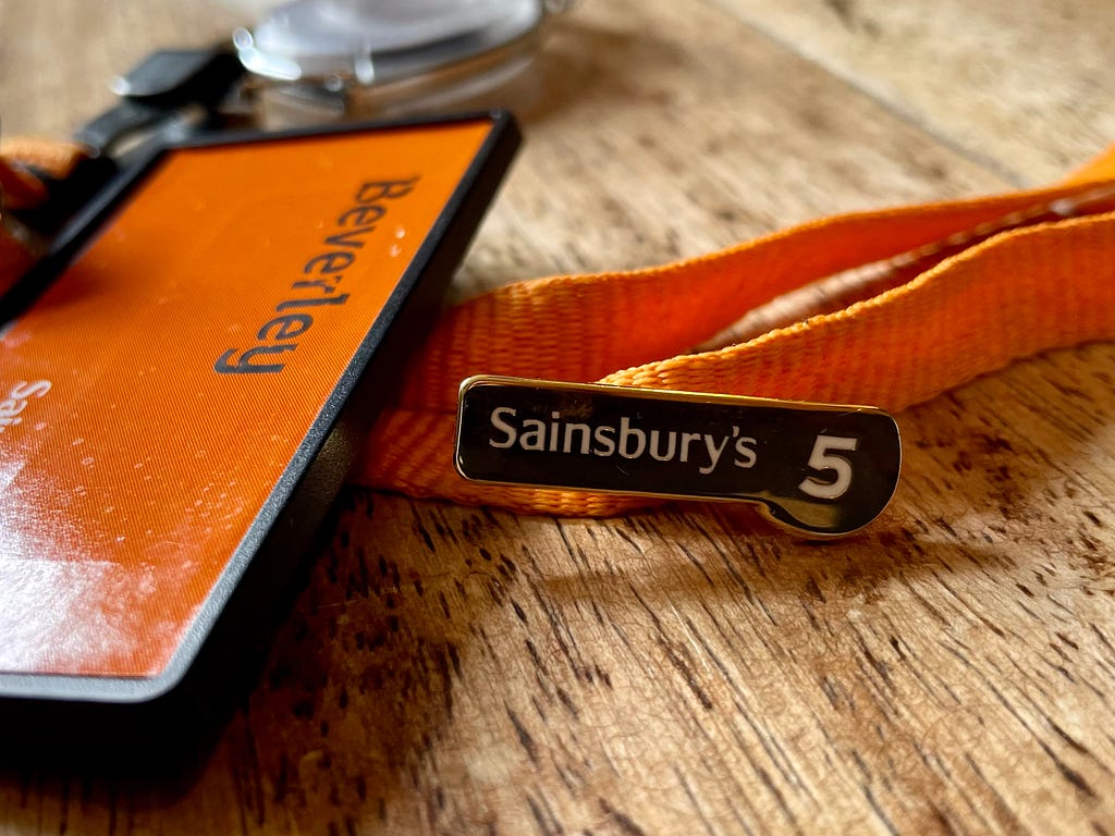 Sainsbury’s 5 year long service badge and name badge on orange lanyard