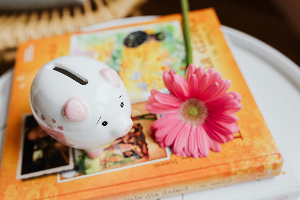 A photo of a white piggy bank and a pink