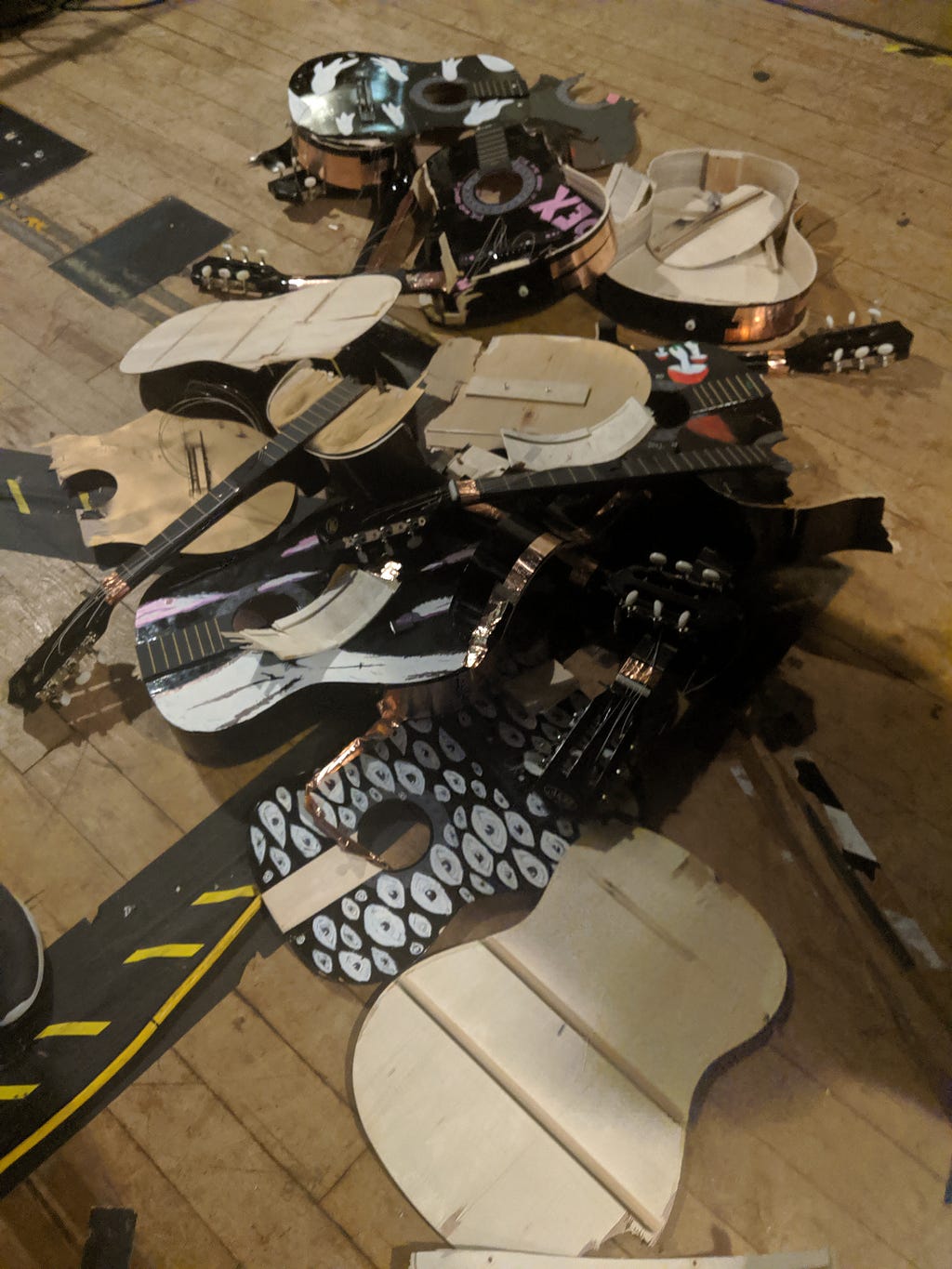 a pile of smashed guitars, their face plates battered.