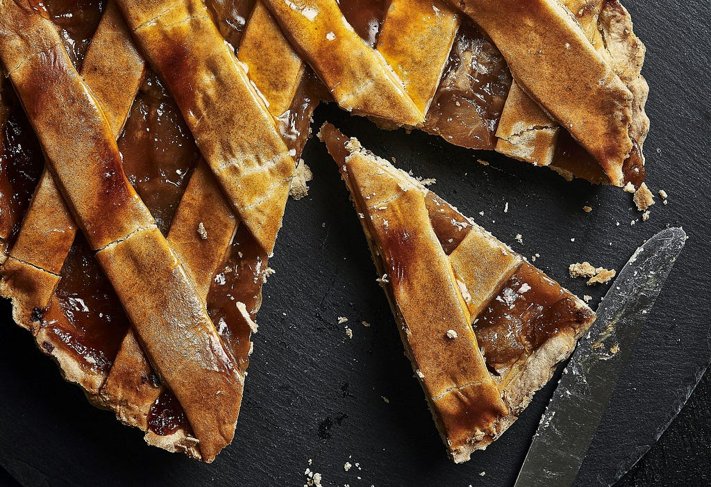 A latticed pie with a slice cut from it