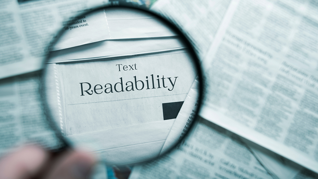 Magnifying glass focusing on the words ‘Text Readability’ in a newspaper, emphasizing the importance of readable content in UX design.