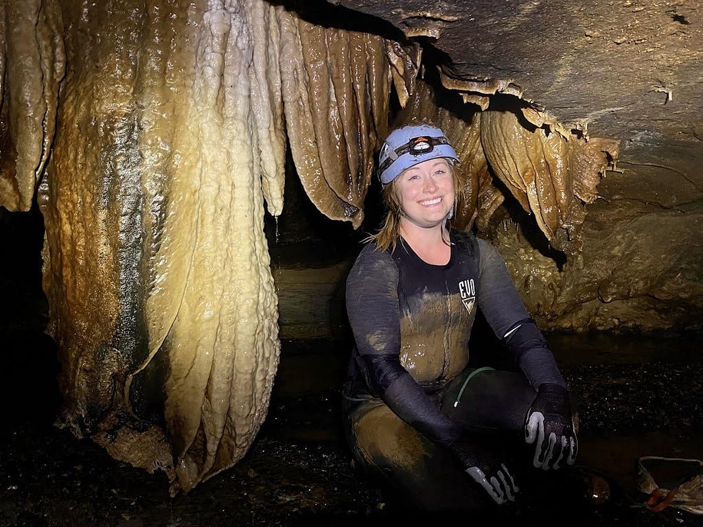 Kris Budd, FWS Scholar and Biologist with the USFWS Ecological Services in the Missouri Field Office smiling big in a cavern.