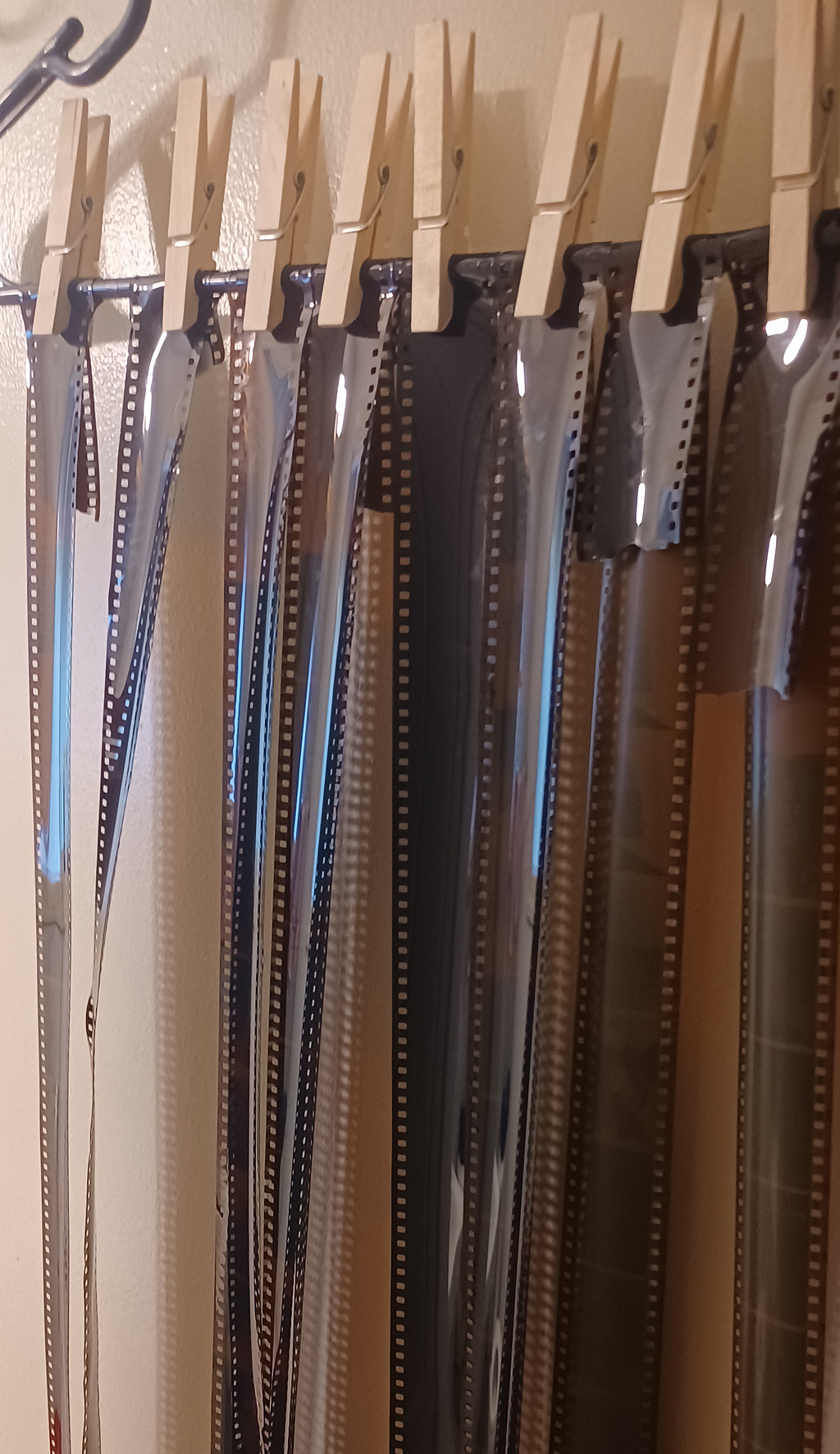 35mm film hanging up to dry with woodden clothes pins.