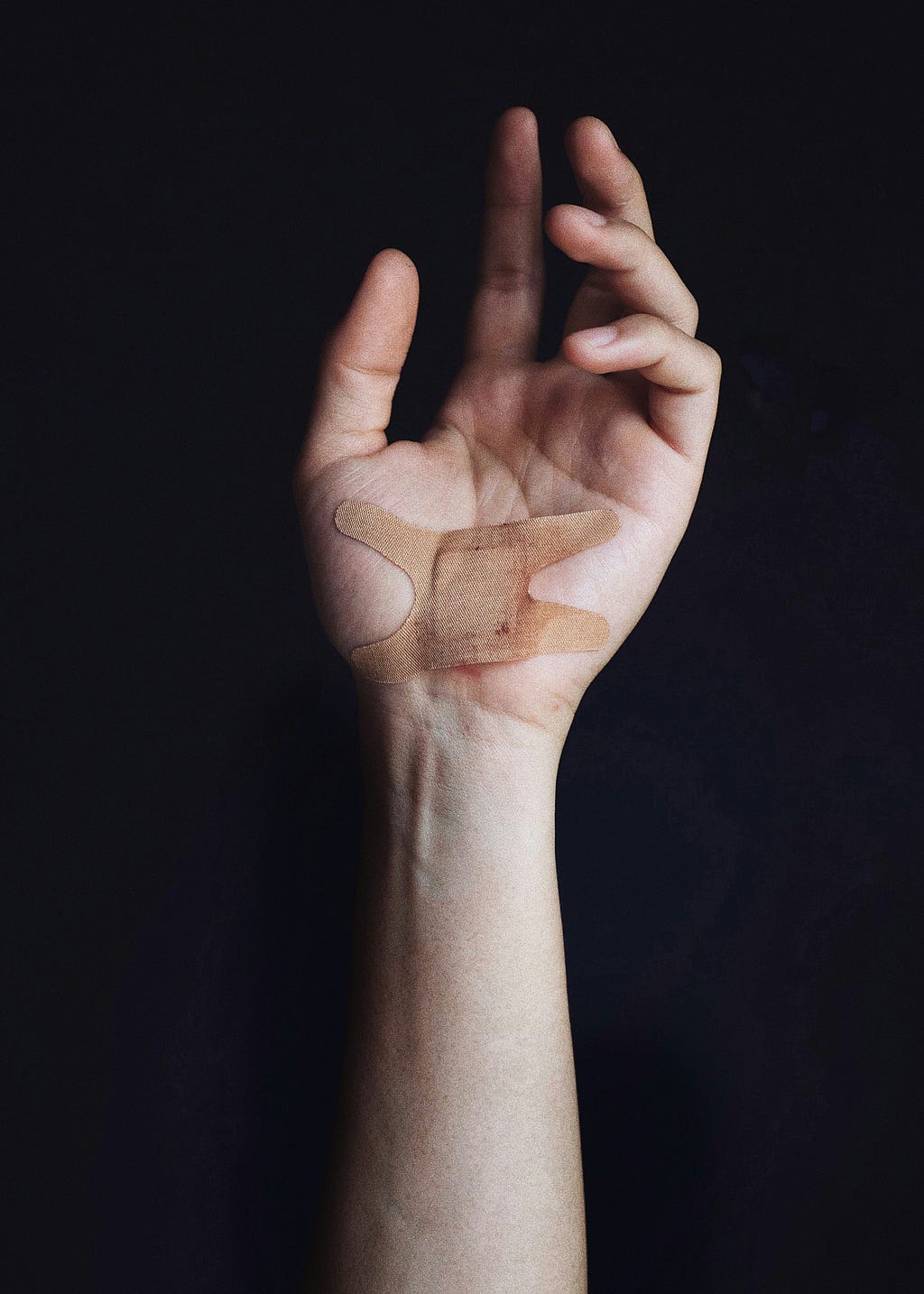 A photo of a hand with a cut and a bandage on it