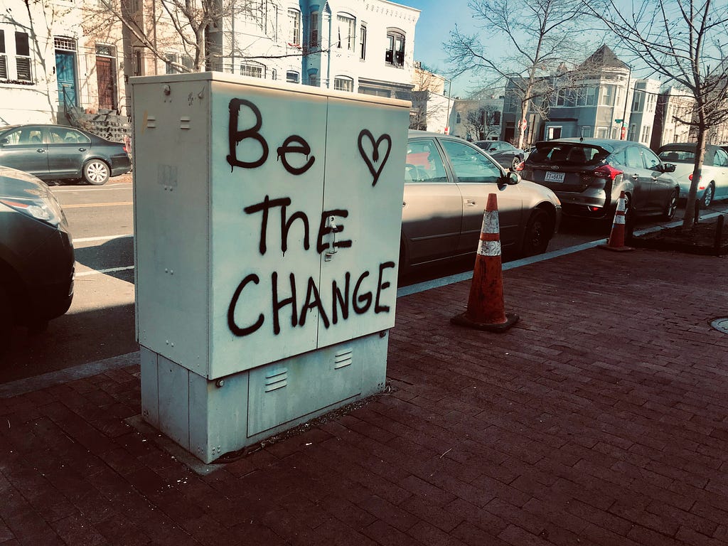 An electrical cabinet with the text “Be the change ❤” written upon it.