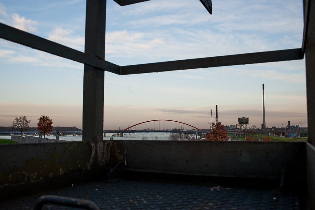 Rheinpark and the very wide Rhine river as seen through a platform of the railway bridge that forms the southern edge of the park. Duisburg, Germany, December 16, 2023.