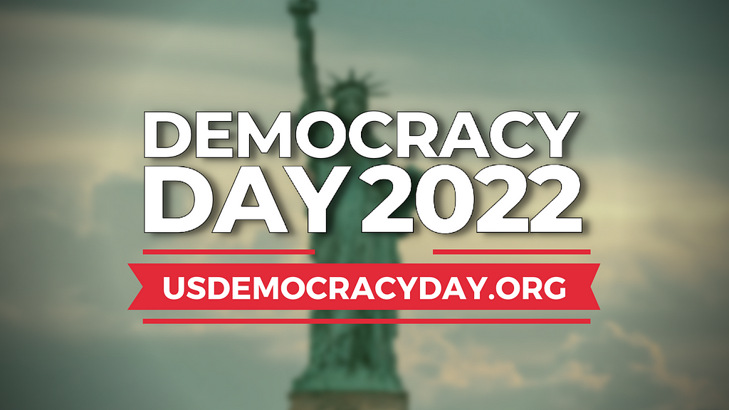 The Democracy Day 2022 logo against a blurry photo of the Statue of Liberty in the background.