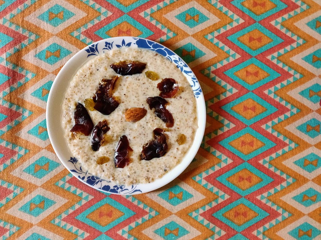 Broken wheat cooked in milk mainly with jaggery and topped with soaked nuts and dates