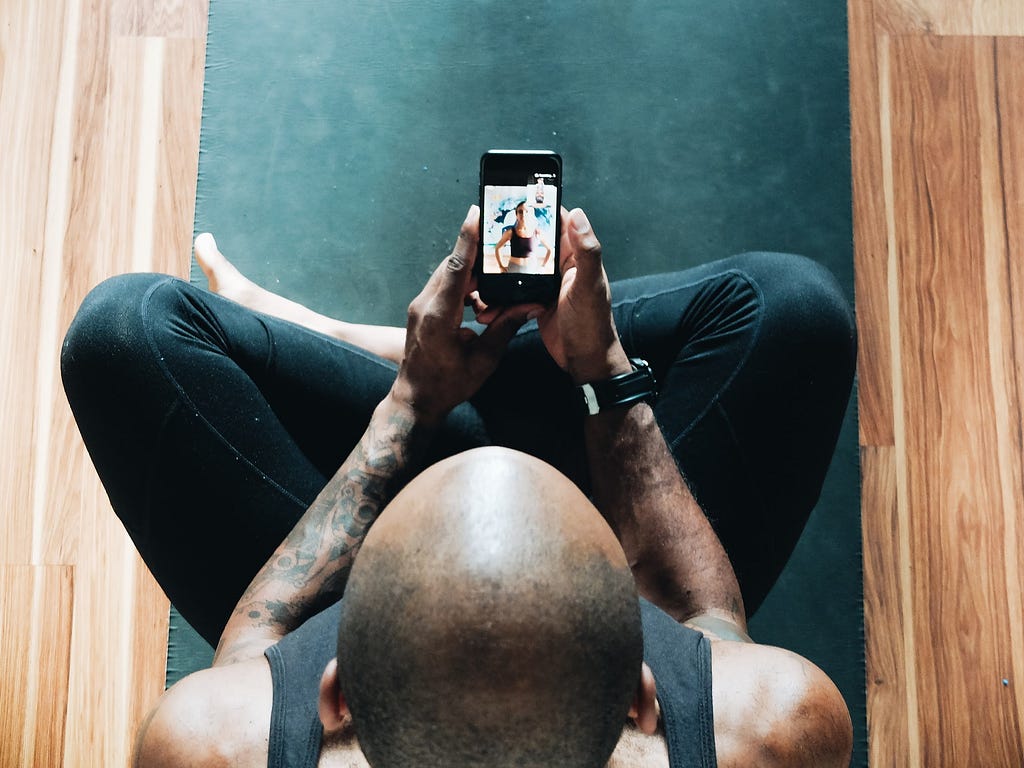 HIIT & Flow instructor looking at his phone for a virtual training