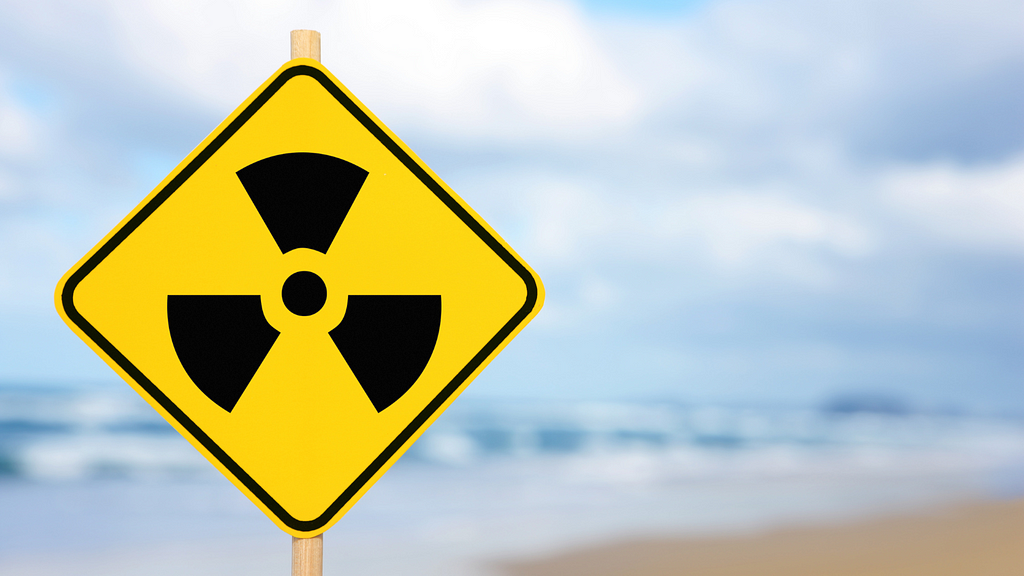 A sign on a beach boasting a radioactive symbol