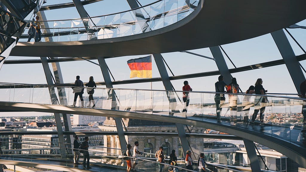 View from the top of the “Bundestag” in Berlin with people in the front, looking out over the city.