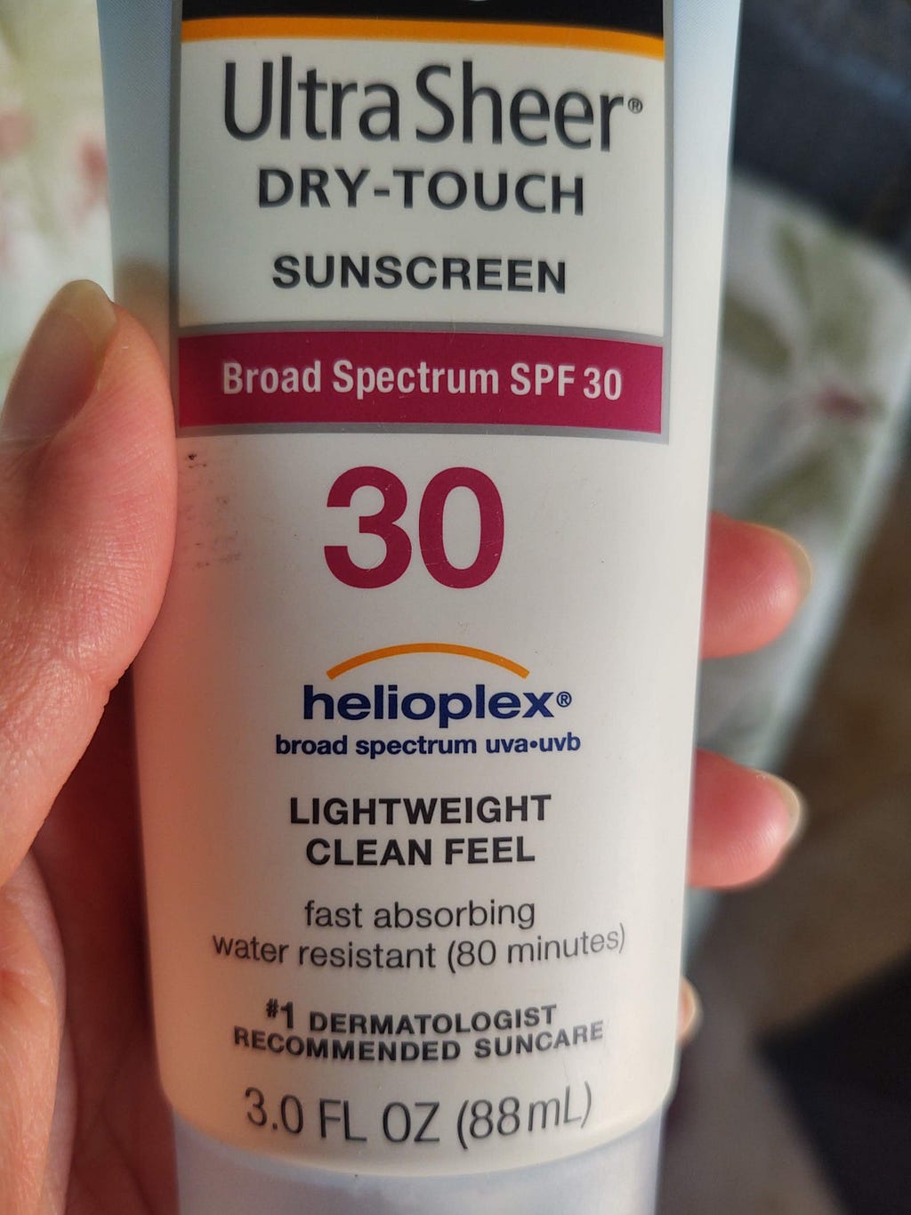 A bottle of lightweight sunscreen with a yellow arc symbol to portray protection