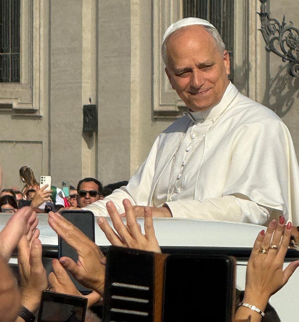 Pope Leo looks out at crowd at St. Peter’s Square on September 17, 2025 as hands reach up to touch him or take his photograph.
