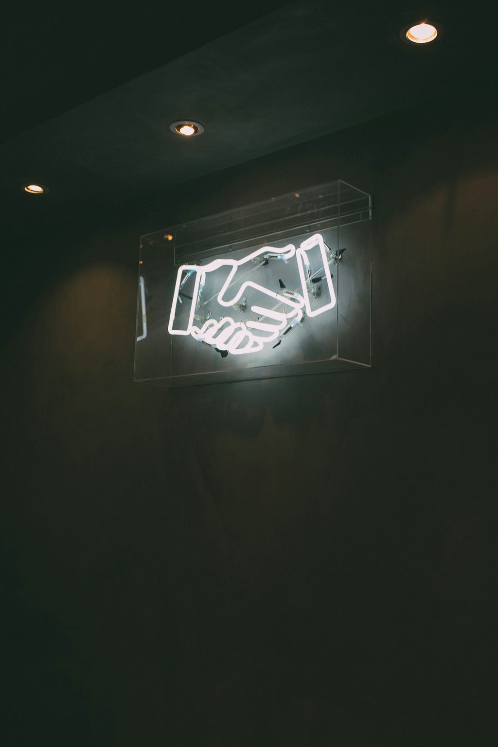 Neon signage of a human handshake